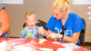 Counselor baking with a camper