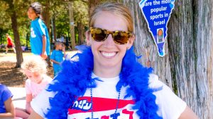 Camper dressed up in a blue feather boa and sunglasses