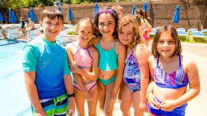 Campers in swimming gear by the pool